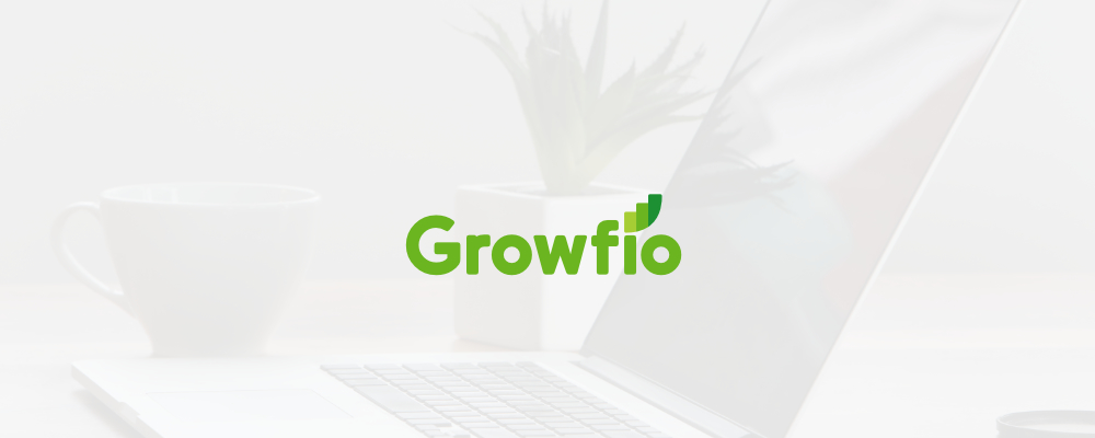 Laptop, phone, plant, and coffe cup on a desk with Growfio's new logo above all